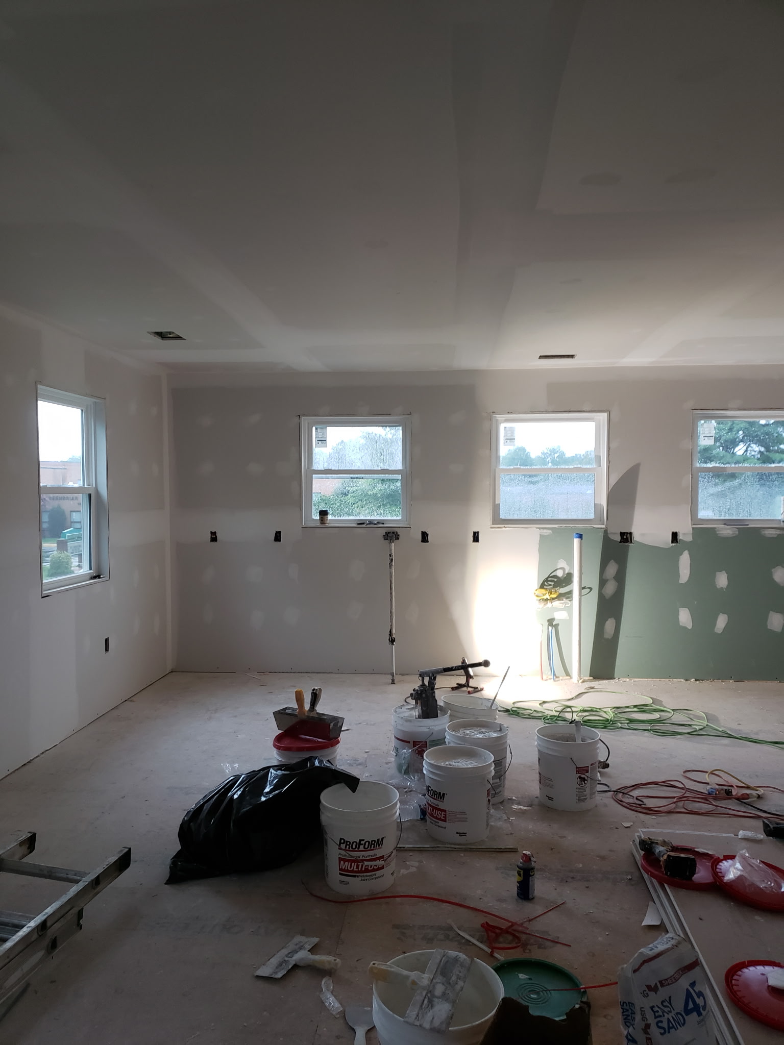 Large interior room during drywall taping and joint-compound finishing