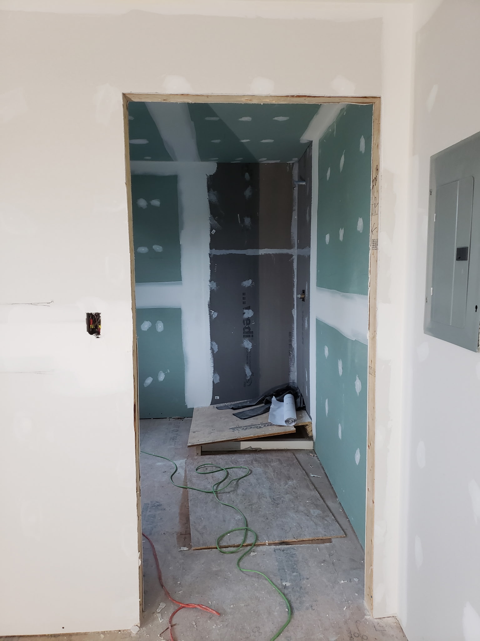 Interior renovation area with drywall finishing around a bathroom opening