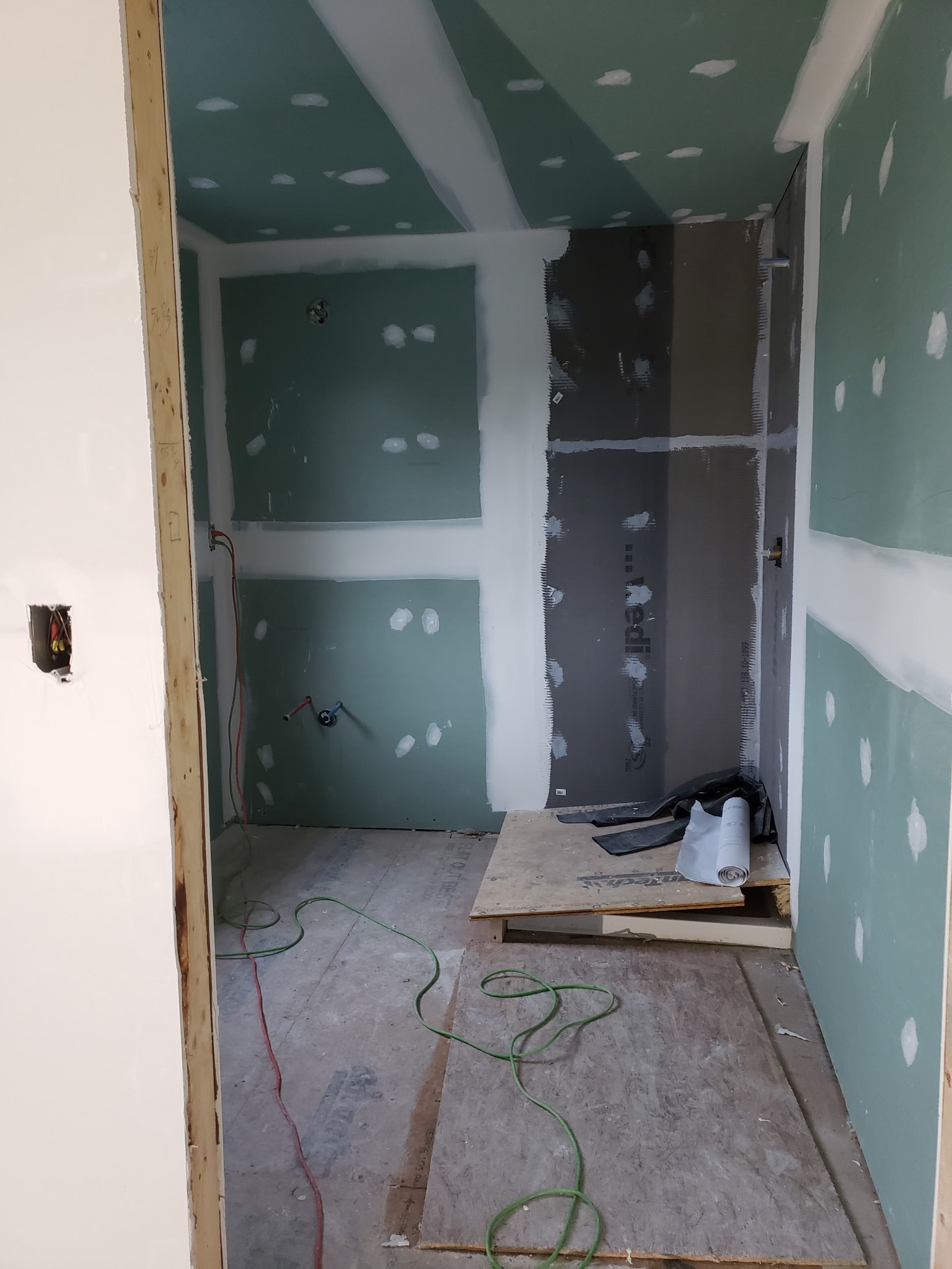 Close view of taped greenboard walls and ceiling during finishing