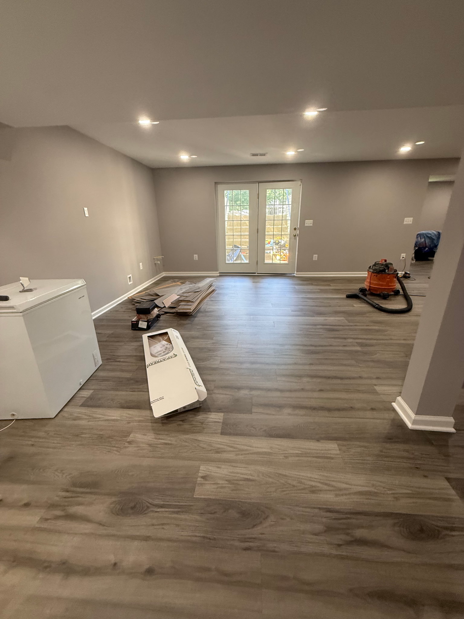 Open finished basement space with plank flooring, painted walls, and recessed lighting