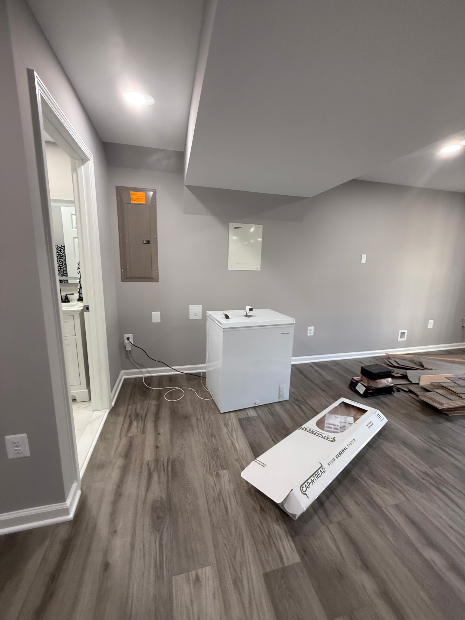 Finished basement utility area with plank flooring, painted walls, trim, and recessed lights